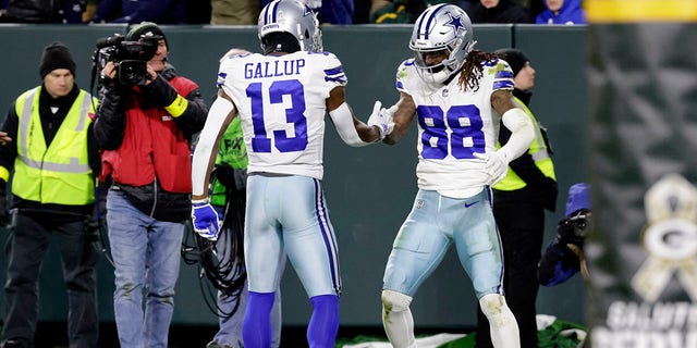 Dallas Cowboys' Michael Gallup (13) and CeeDee Lamb (88) celebrate Lamb's touchdown catch during the second half of an NFL football game against the Green Bay Packers Sunday, Nov. 13, 2022, in Green Bay, Wis.