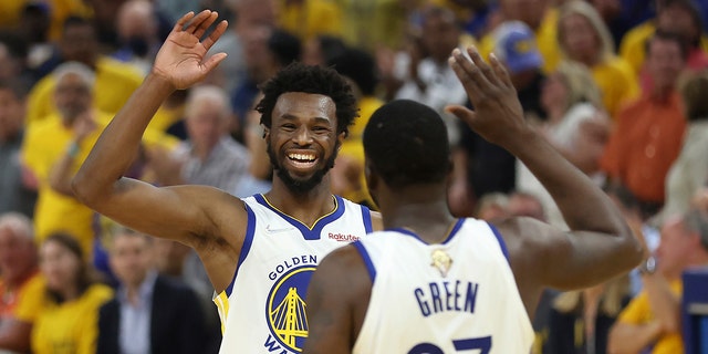 Golden State Warriors forward Andrew Wiggins, left, celebrates with forward Draymond Green (23) during the first half of Game 5 of the NBA Finals against the Boston Celtics in San Francisco June 13, 2022. 