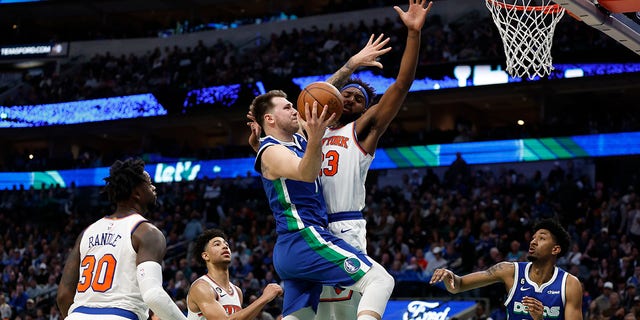 Luka Doncic of the Dallas Mavericks drives to the basket against the New York Knicks' Mitchell Robinson in the second half of their game at American Airlines Center in Dallas on Dec. 27, 2022.